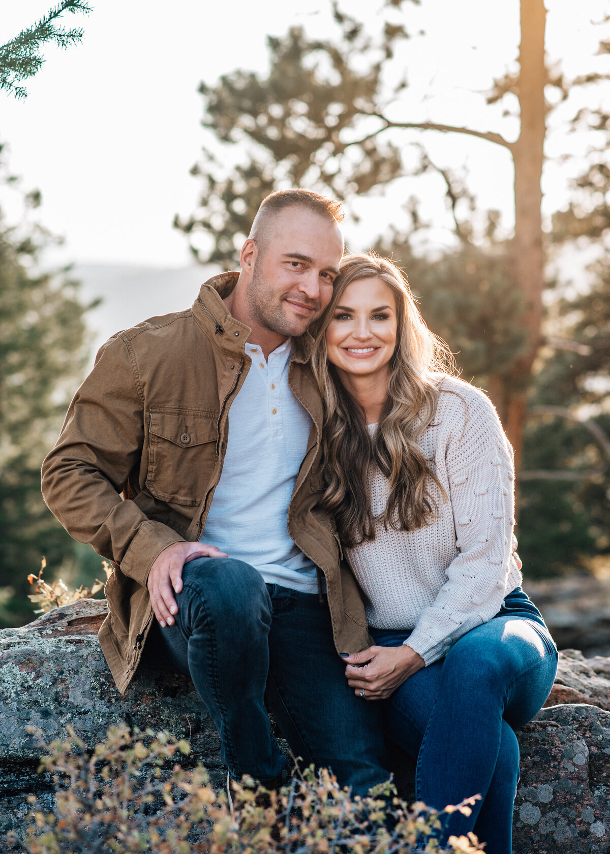 denver couples photography with denver family photographers capturing mother and father sitting together in a fall forest while leaning into each other