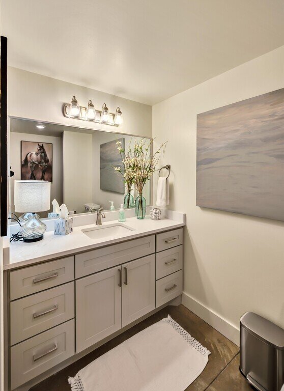 Single bathroom vanity with large mirror and plenty of counter space in this 2 bedroom, 2.5 bathroom luxury vacation rental loft condo for 8 guests with incredible downtown views, free parking, free wifi and professional decor in downtown Waco, TX.