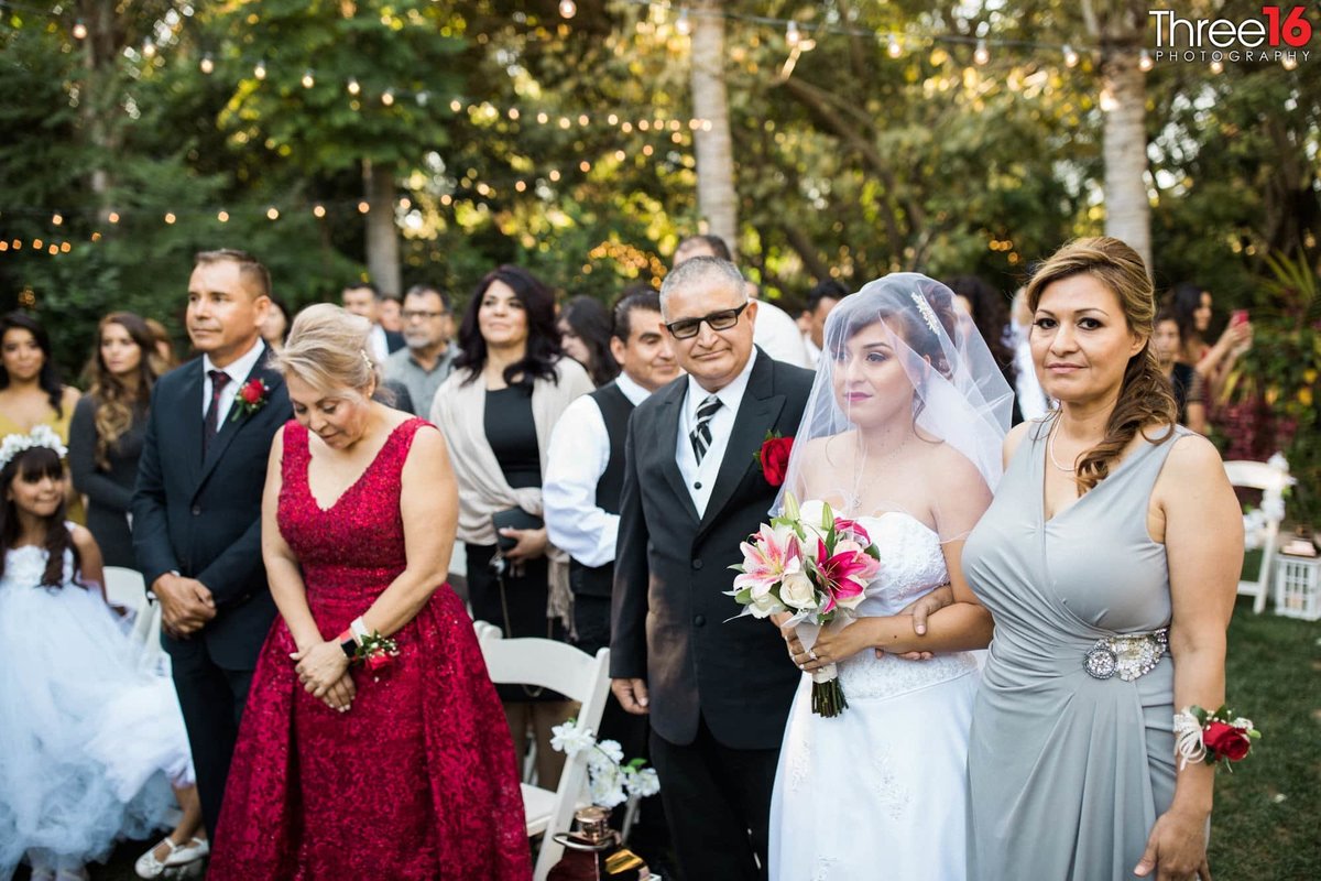 Parents walking their daughter down the aisle