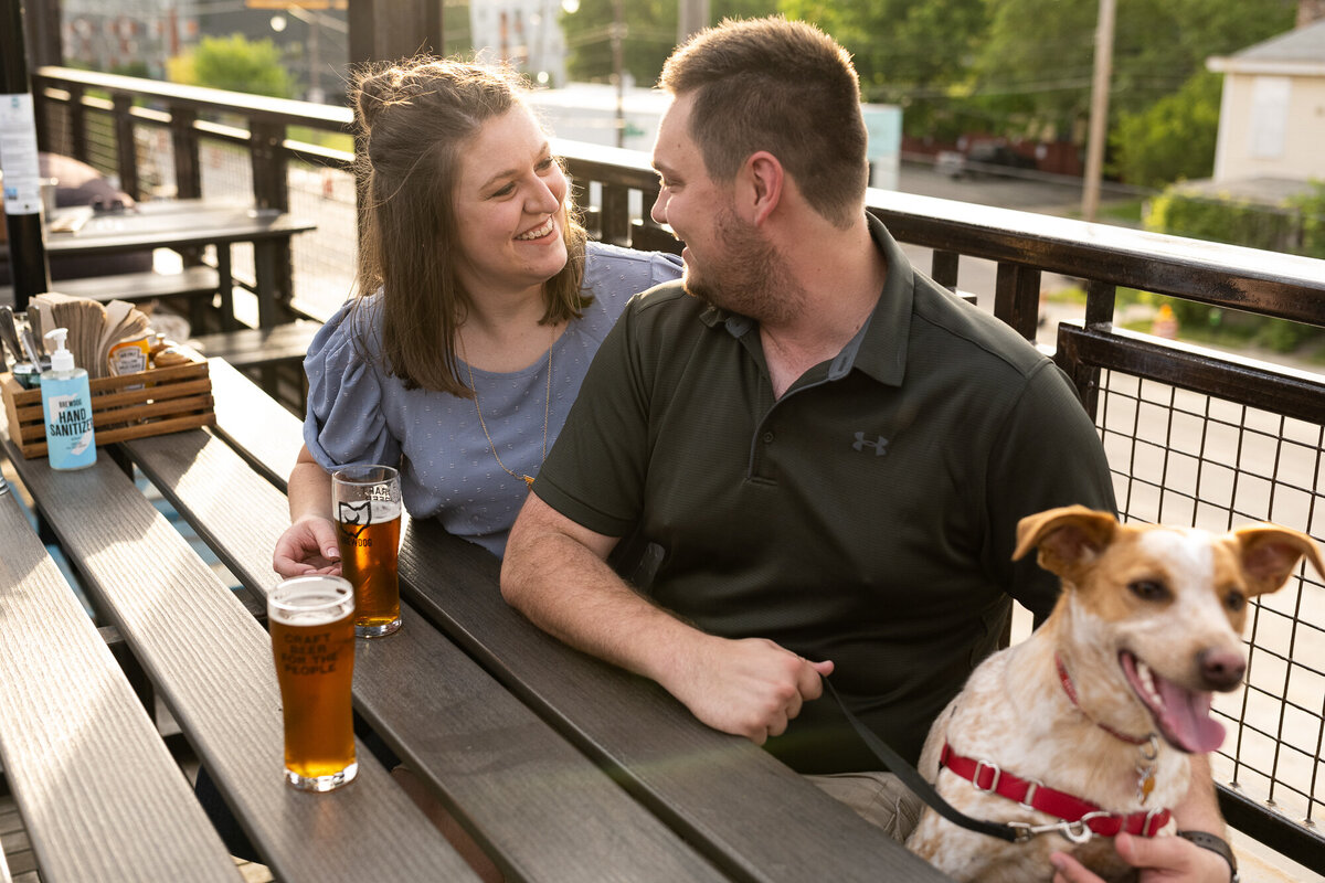 Couple with their dog sharing a beer at Franklinton BrewDog