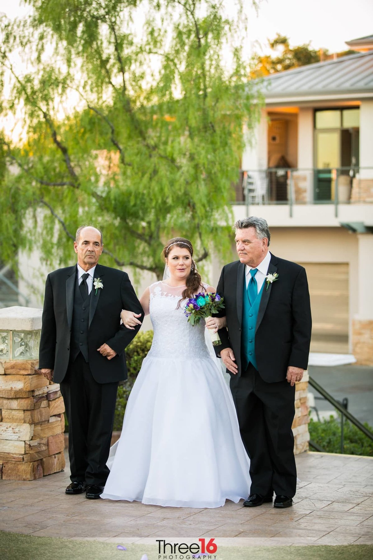 Bride being escorted by her two dads