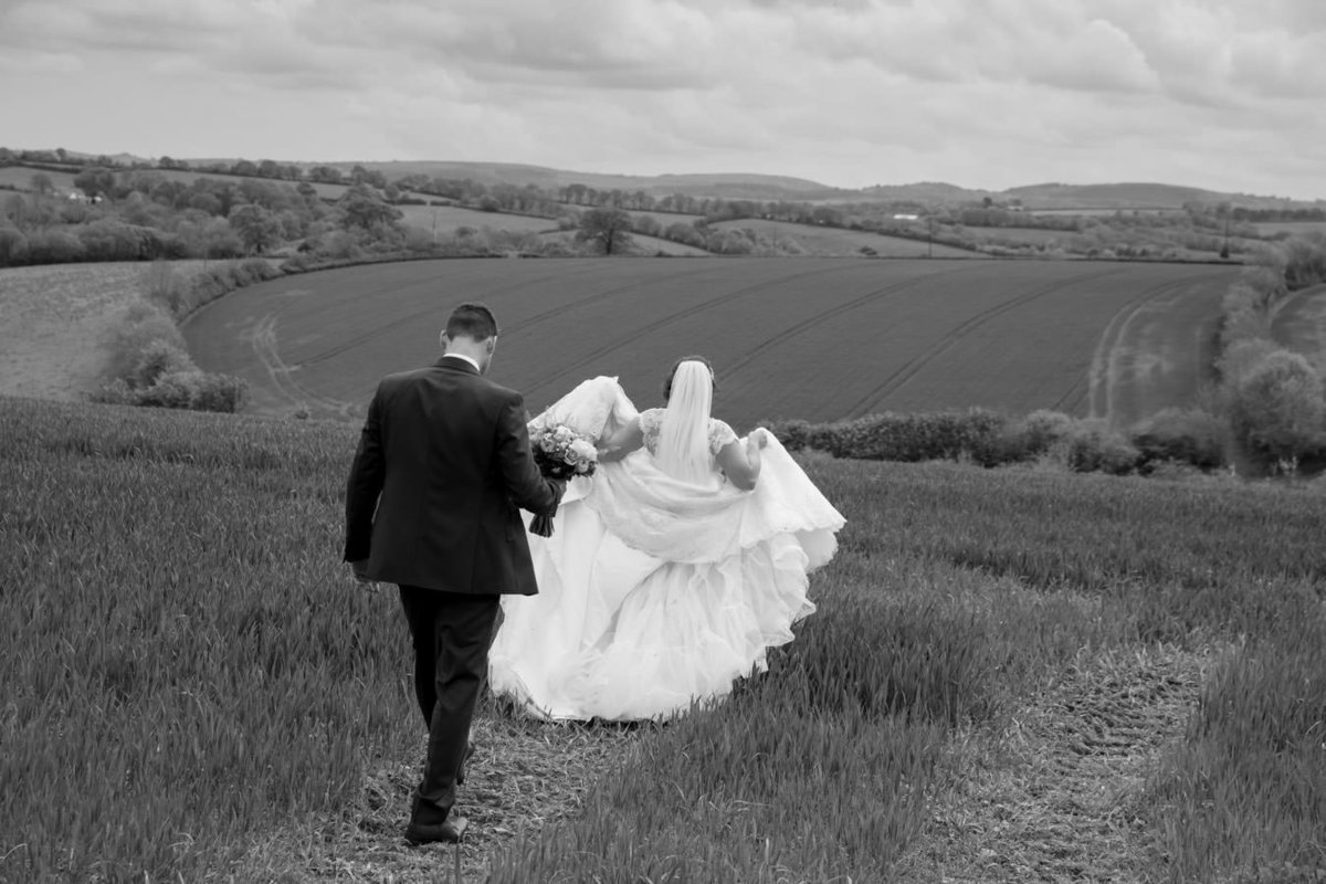 Black and white wedding couple in field at The Oak Barn Devon