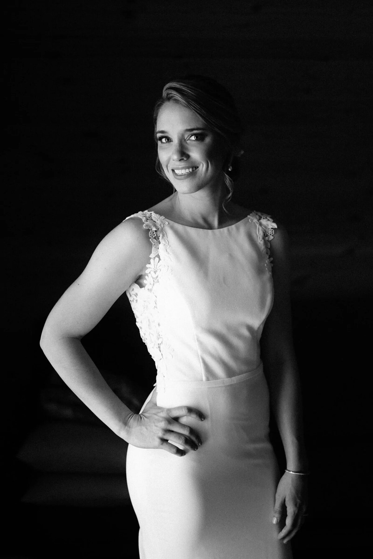 A bride smiling with one hand on her hip