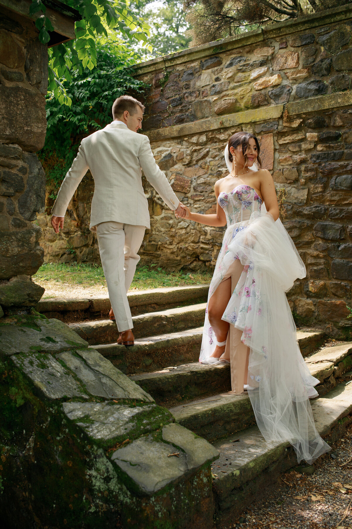 bride and groom walking up steps at their wedding venue