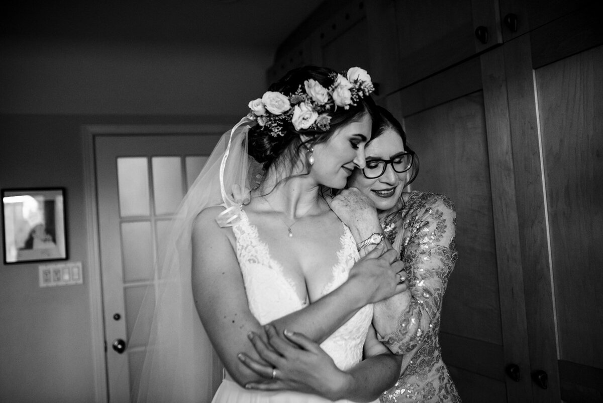 Bride getting hugged by mom on her wedding day