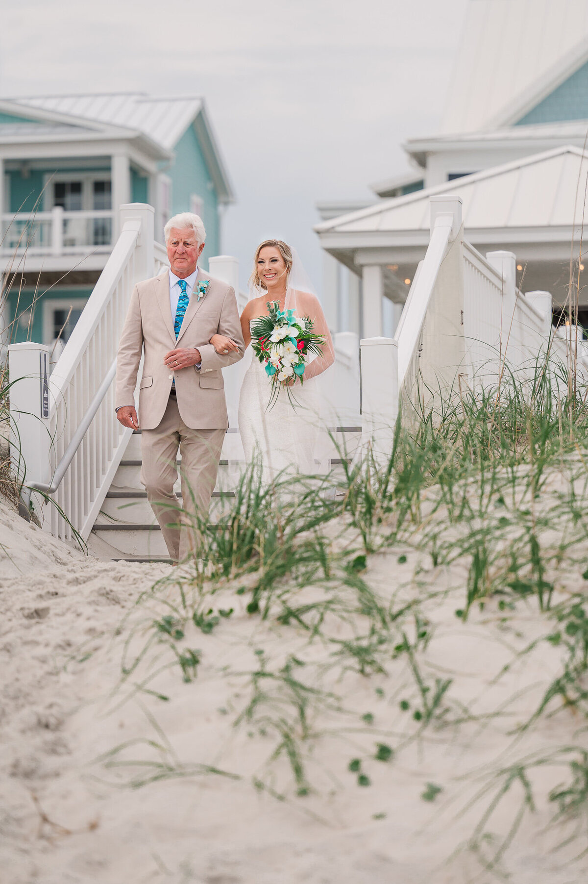 The father of the bride walking his daughter down the aisle on her wedding day at Atlantic Beach by JoLynn Photography, a Raleigh wedding photographer