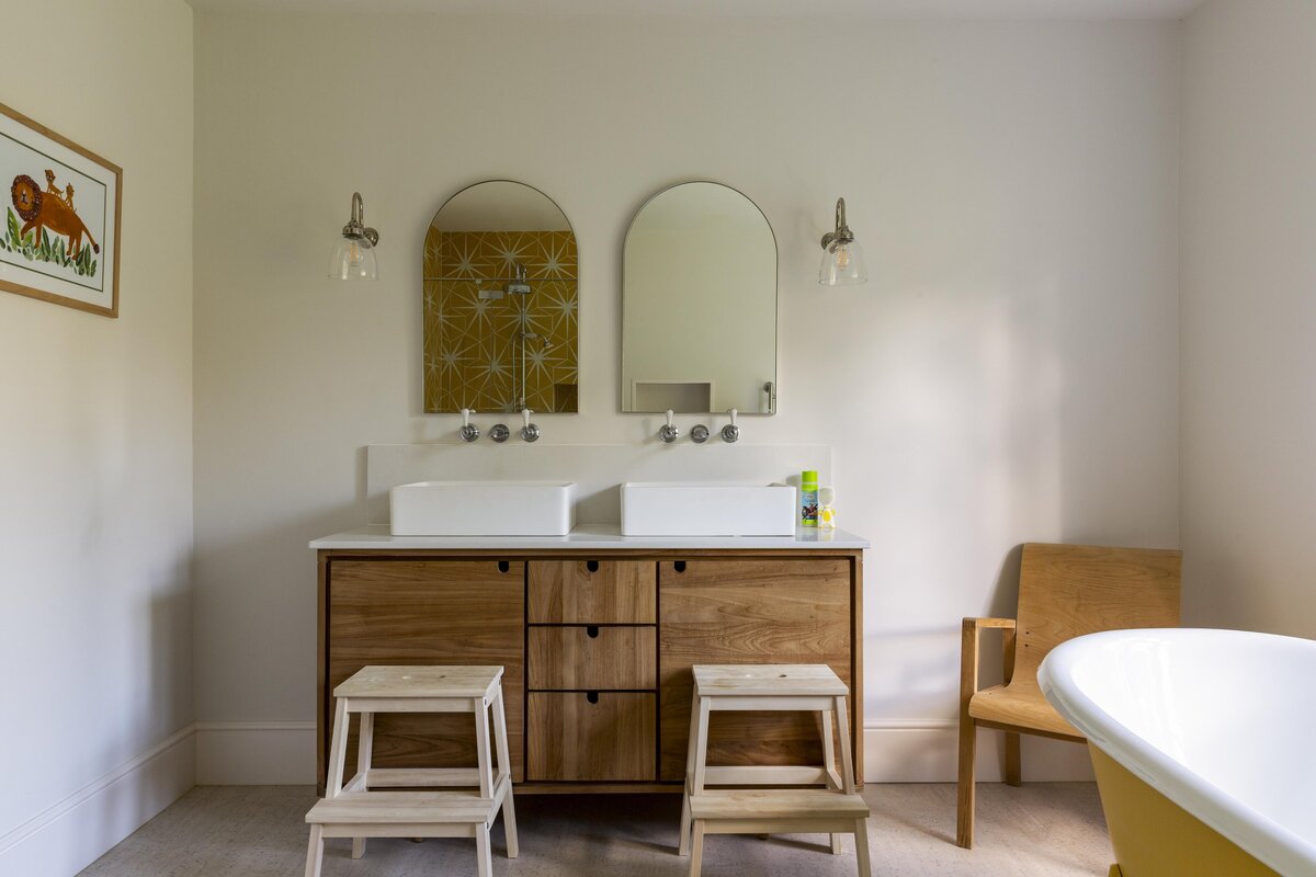 Double sink unit with twin mirrors next to yellow bath