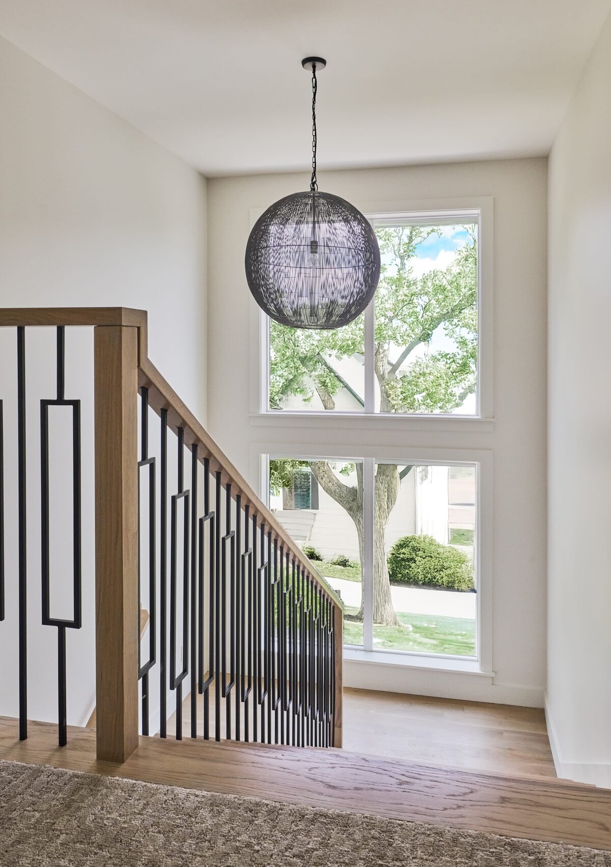 cocoloba homes graham stairwell with black iron railing and large windows