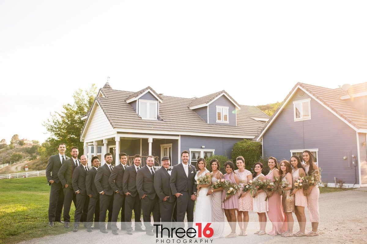 Newly married couple pose together with their bridal party