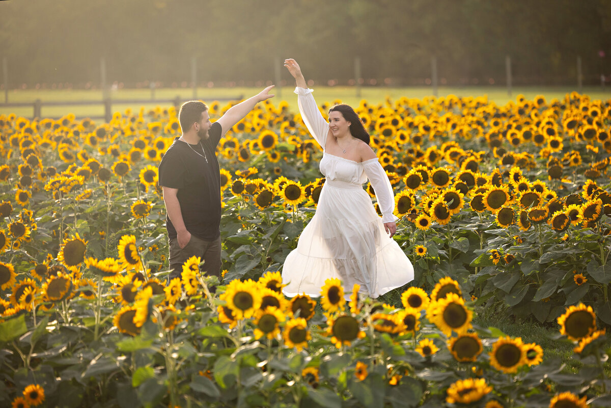 engagement-couple-twirling-sunflower-field-holland-ridge