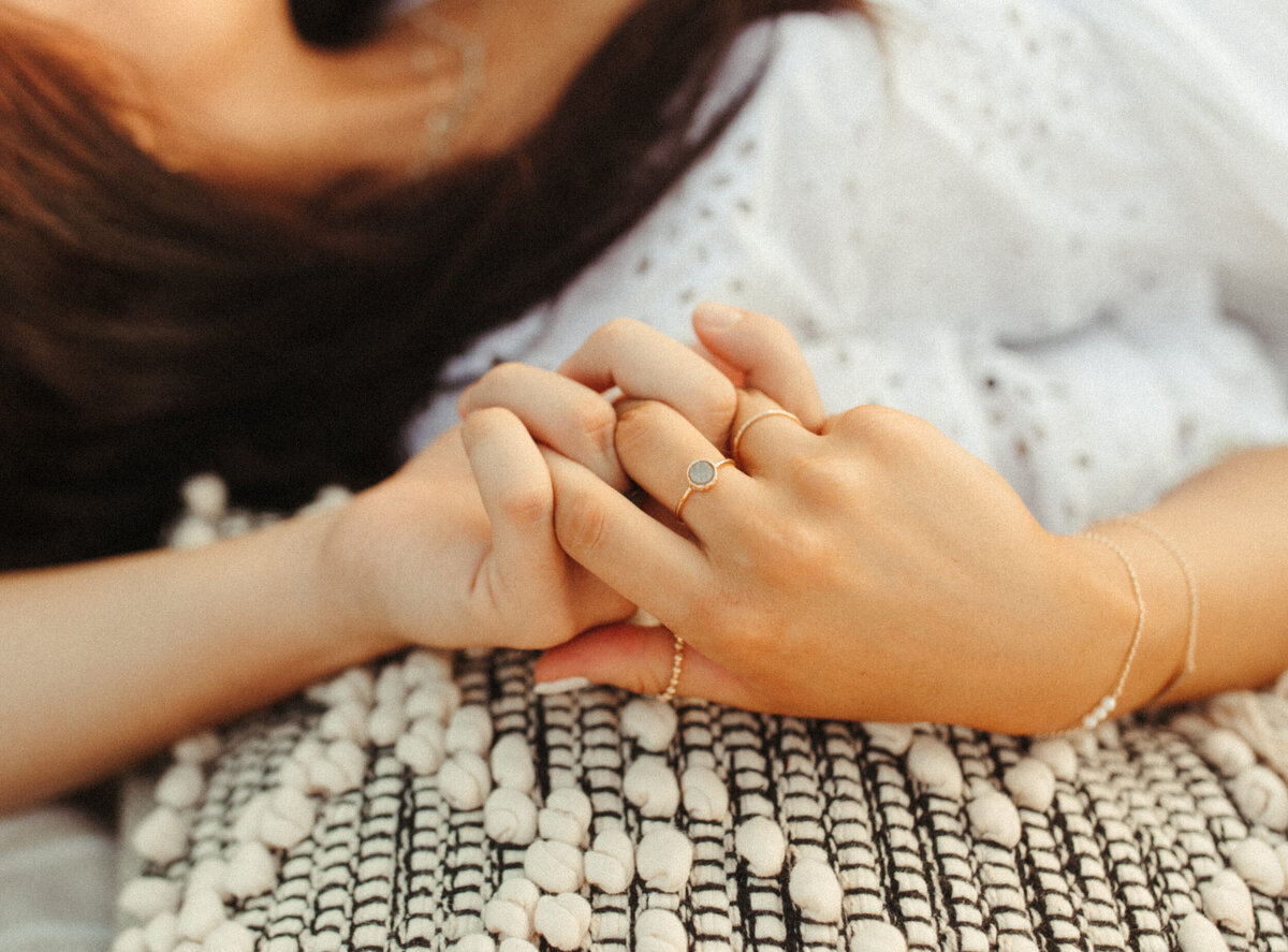 Close up of a couple holding hands on a blanket