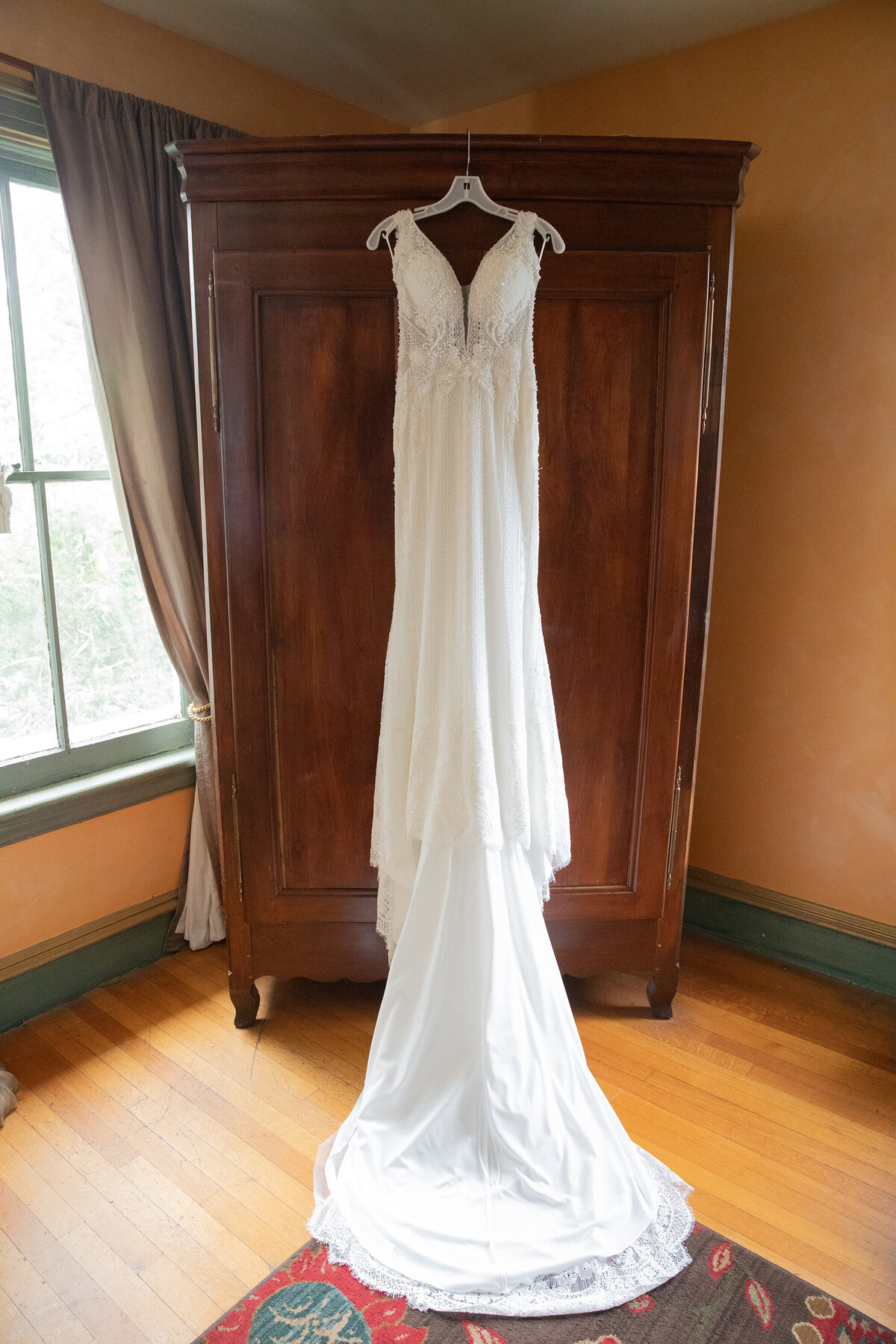 white wedding dress handing in front of a wardobe Westchester wedding photographer