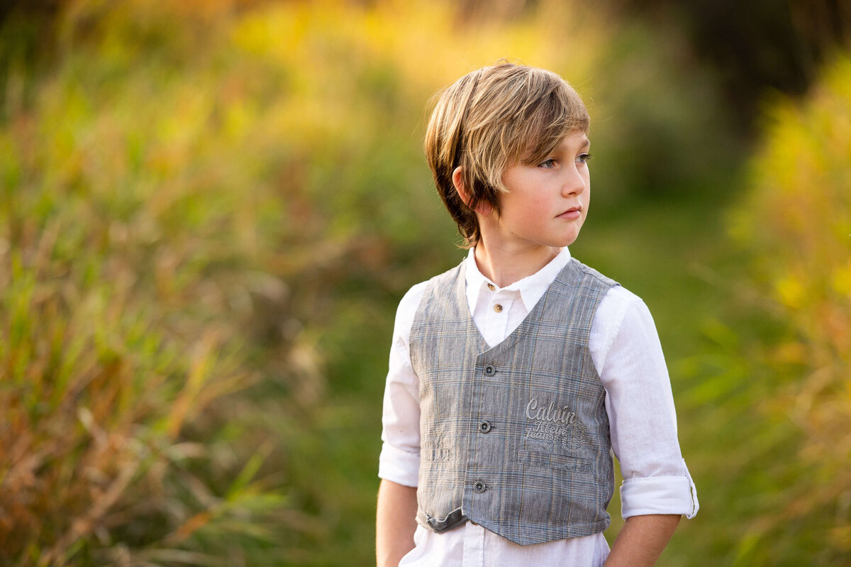 family photos in Ottawa a young boy in a grassy field at sunset golden hour