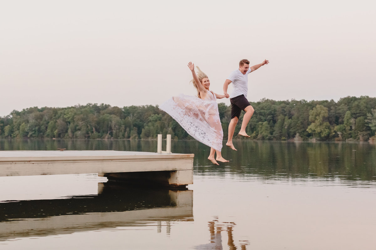 couple jumping off dock at waterfront wedding venue
