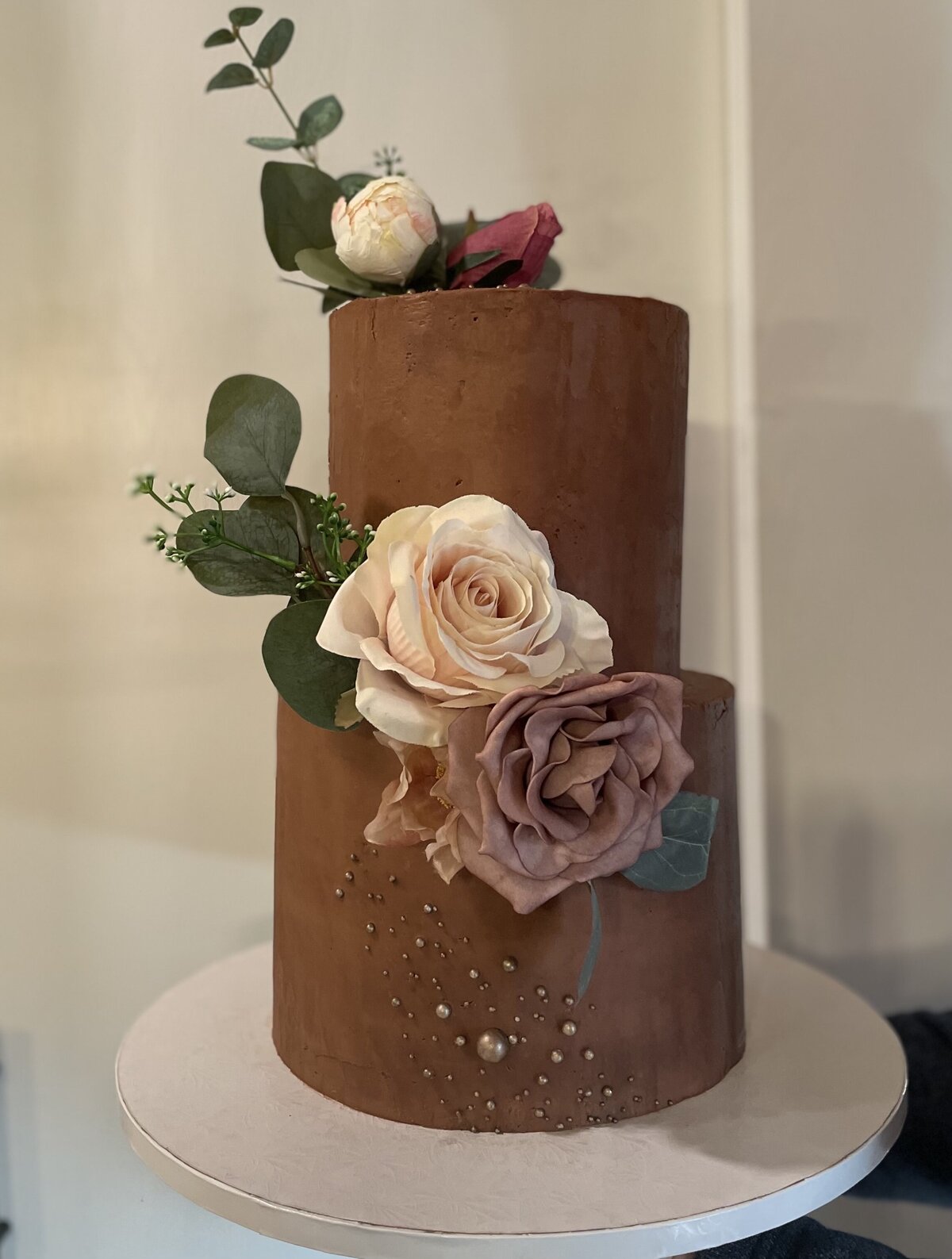 Elegant two-tier wedding cake decorated with fresh flowers, created in Gilbert, AZ
