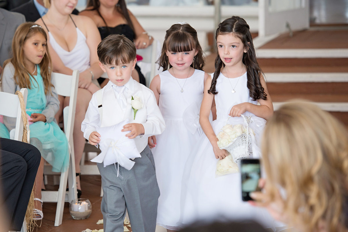 flower girls and ring bearers walking down the aisle at Oceanbleu