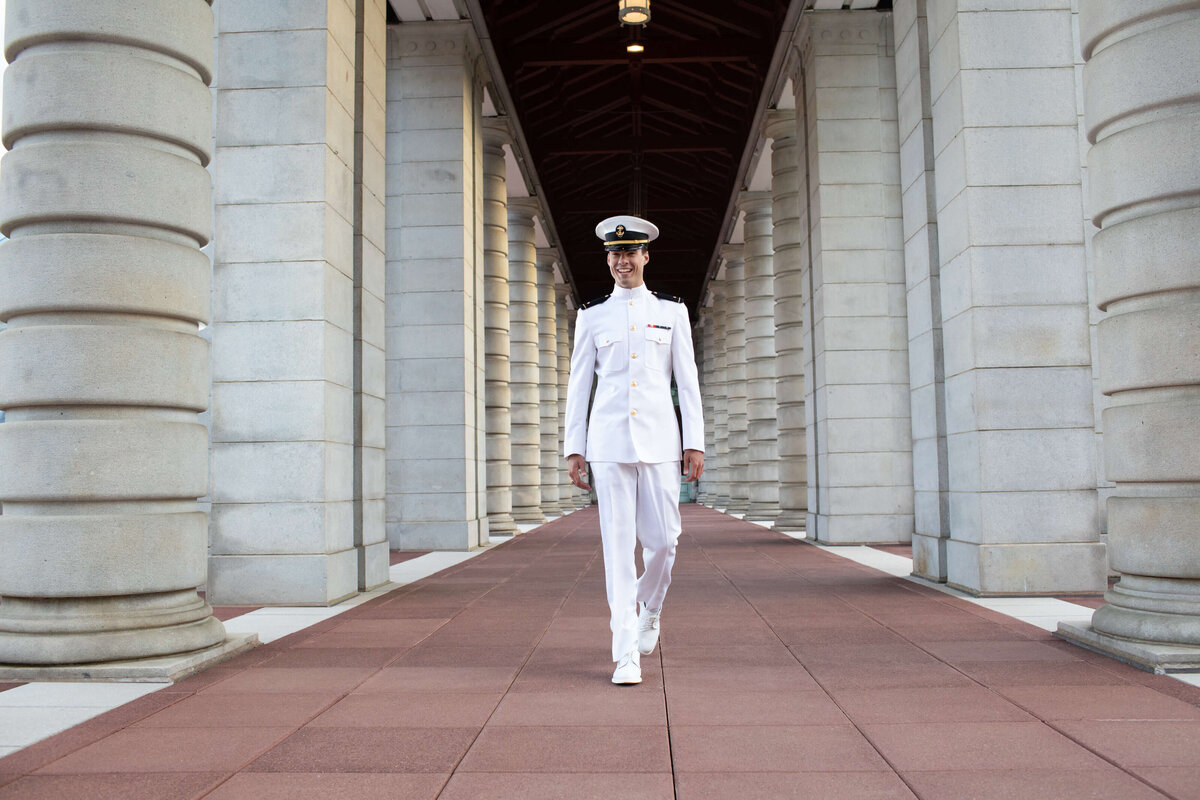 Naval Academy Midshipman senior in Annapolis Maryland walks red beach during a photography session with Kelly Eskelsen.