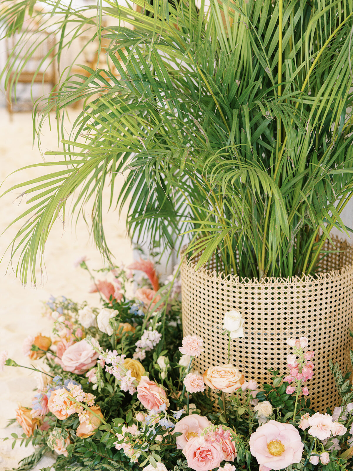 Tropical floral arrangements and floor meadows for tented private estate spring destination beach wedding reception in Exuma, Bahamas. Orchids and roses in tropical colors of orange, pink, lavender, dusty blue pale yellow and natural greens. Destination floral design by Rosemary & Finch Floral Design.