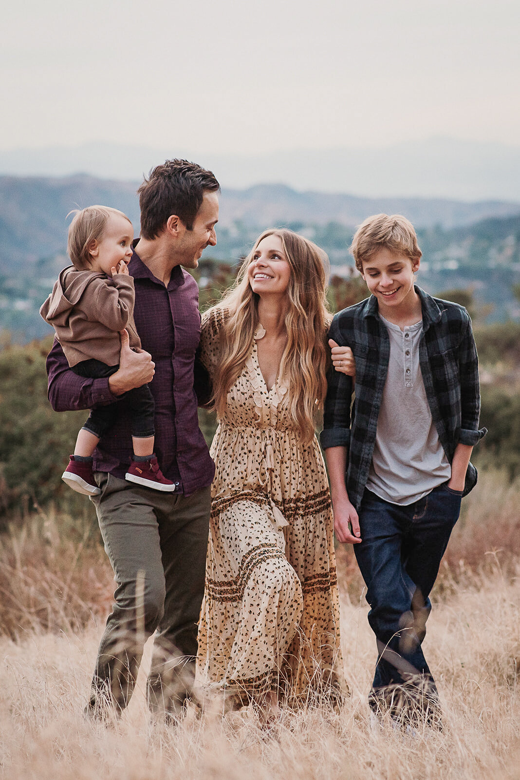 Pasadena family of four walks arm in arm on hillside