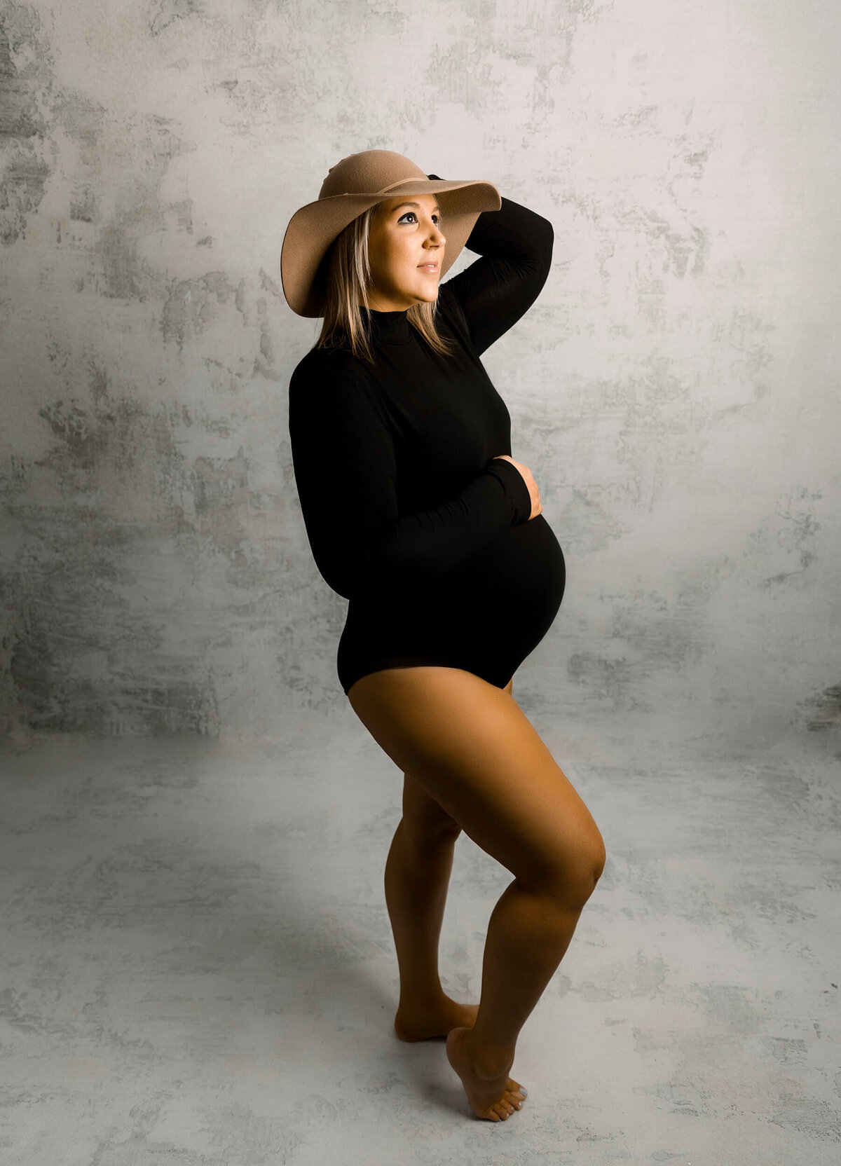 Erie Pa pregnant woman wearing a body suit and hat