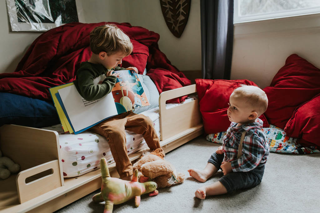 Bay area brothers read together in bedroom at in home family photography session