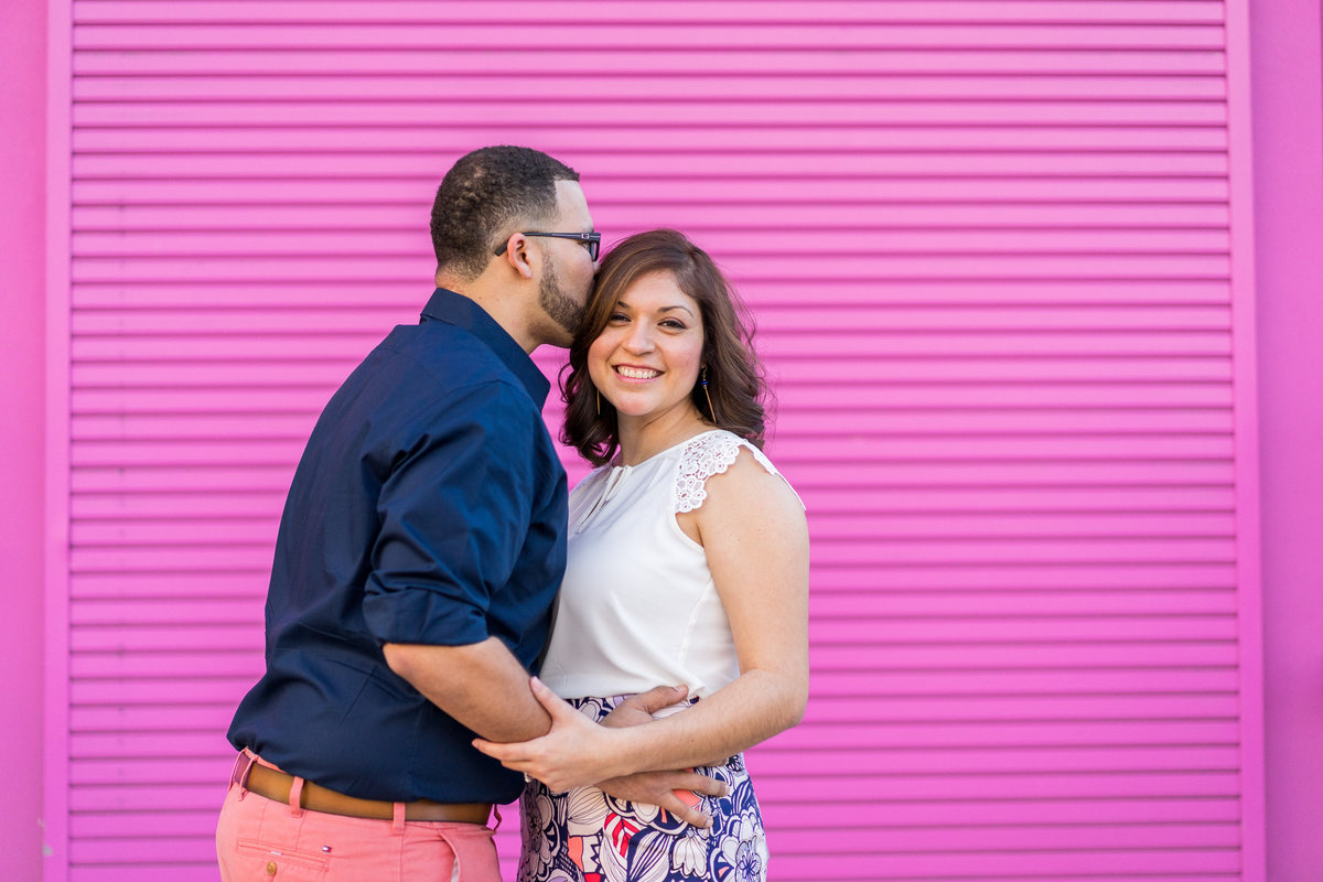 Engaged couple in front of pink wall at Market Square San Antonio