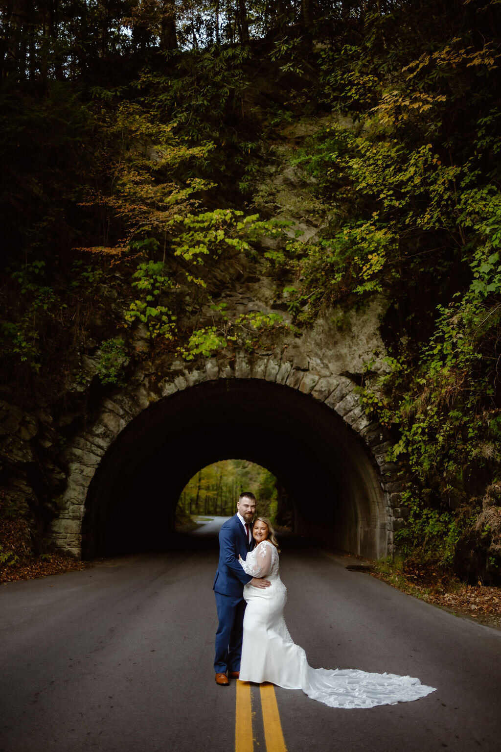 Cades Cove wedding photos with bride and groom standing on a road with e tunnel behind them posing for their Gatlinburg elopement photos captured by gatlinburg photographer