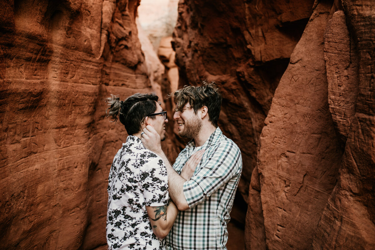 same sex couple looking at each other in red rock canyon