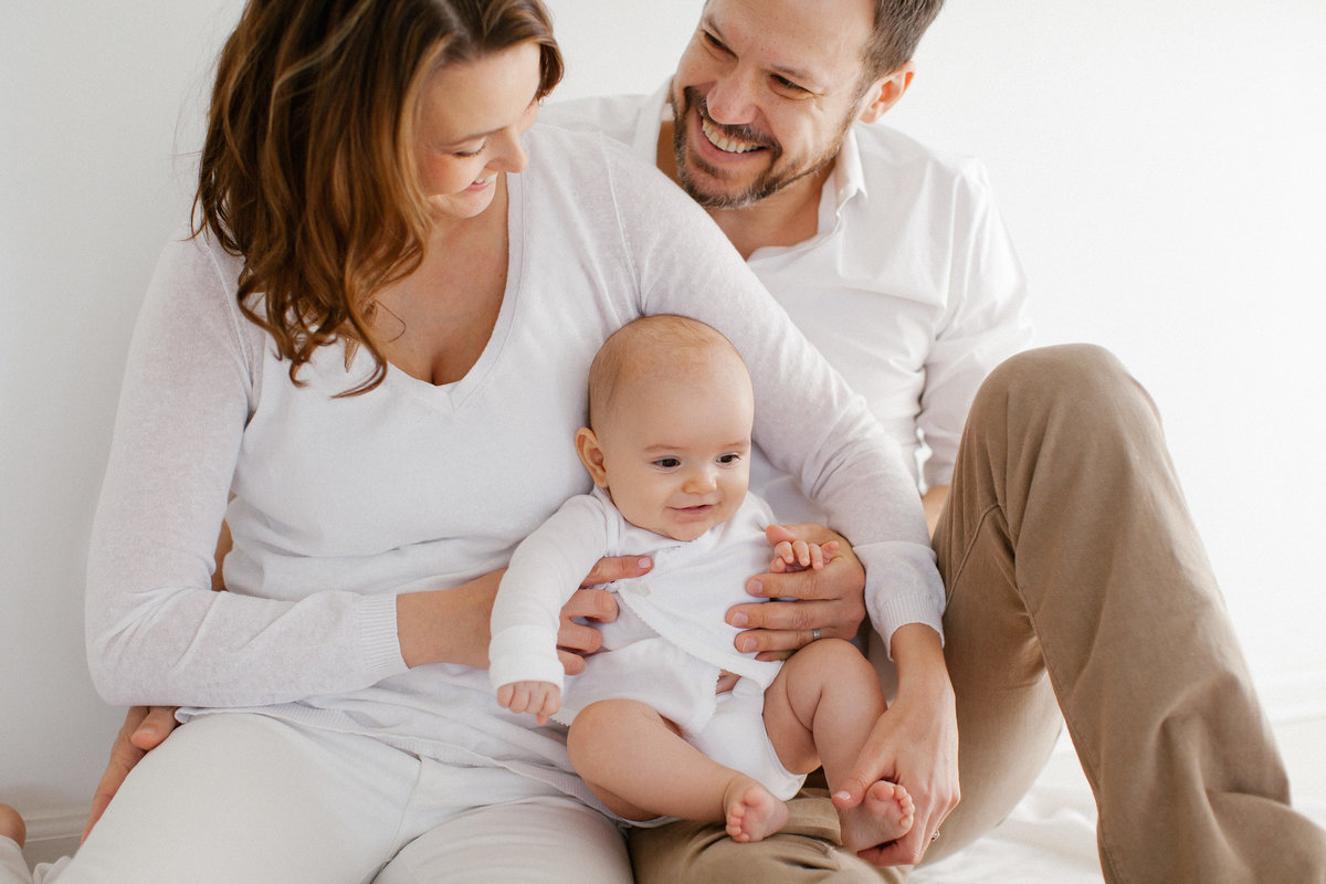 Family of three hold their baby in Chicago photography studio, Photo by Elle Baker Photography