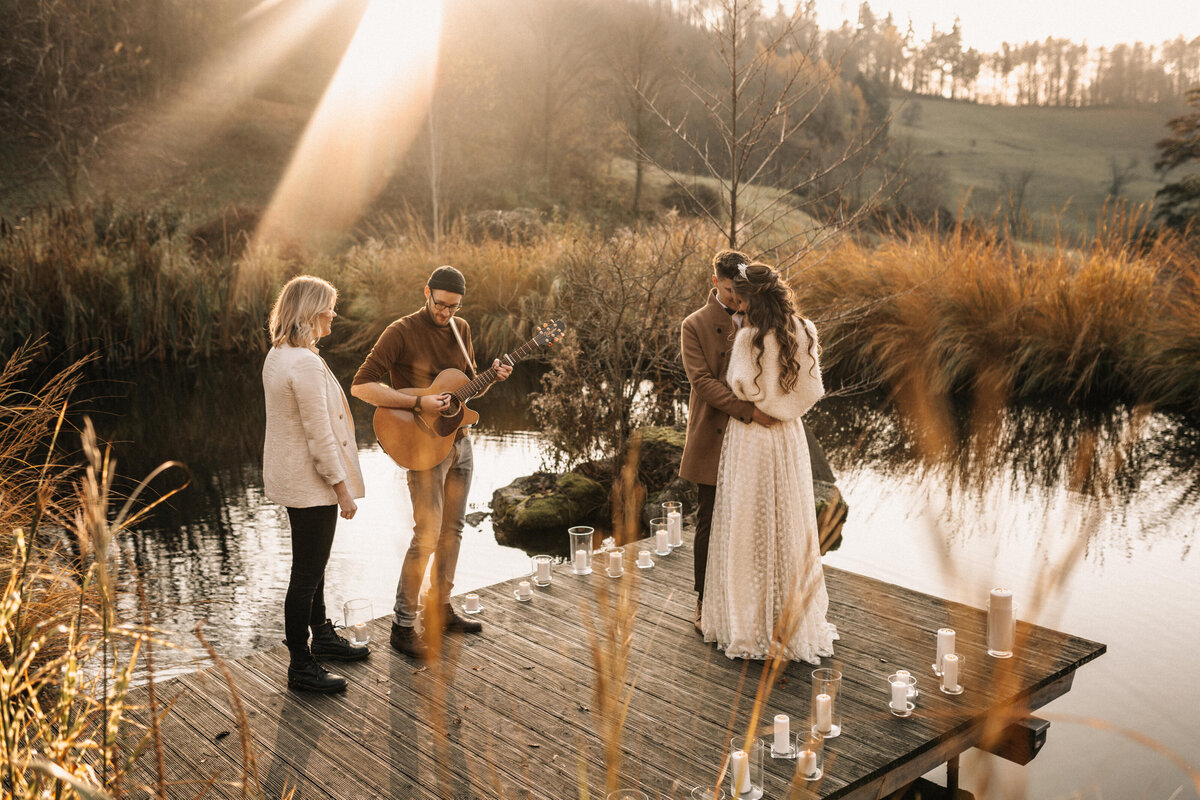 Brautpaar auf einem Steg mit Musikern