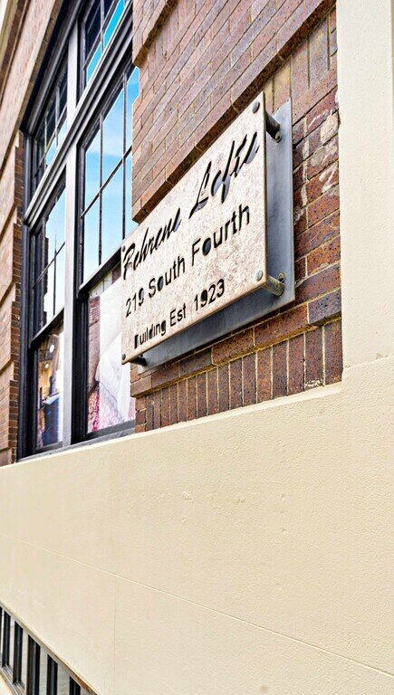 Exterior view of the Behrens Lofts building and sign, which holds this 2 bedroom, 2.5 bathroom luxury vacation rental loft condo for 8 guests with incredible downtown views, free parking, free wifi and professional decor in downtown Waco, TX.