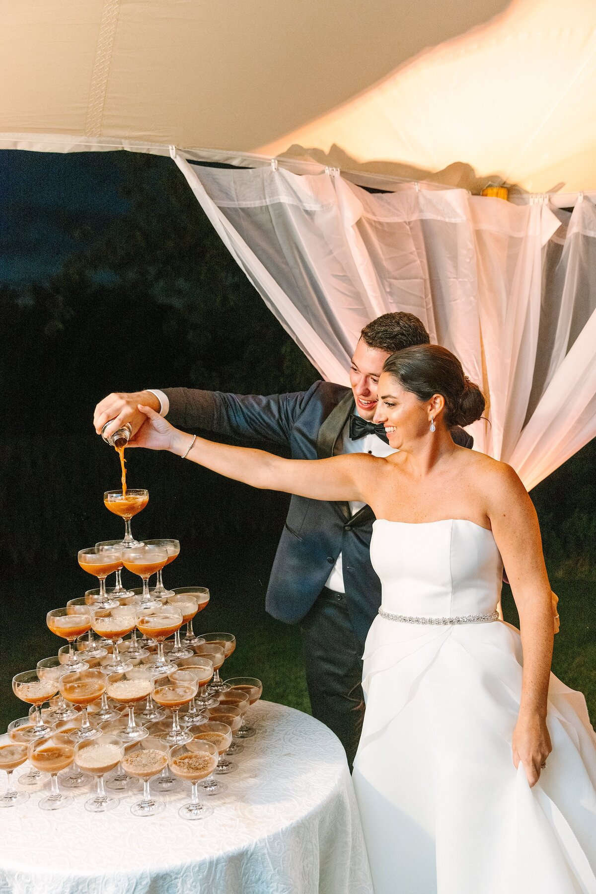 bride and groom pour espresso martini together during the wedding reception in lieu of cutting a cake