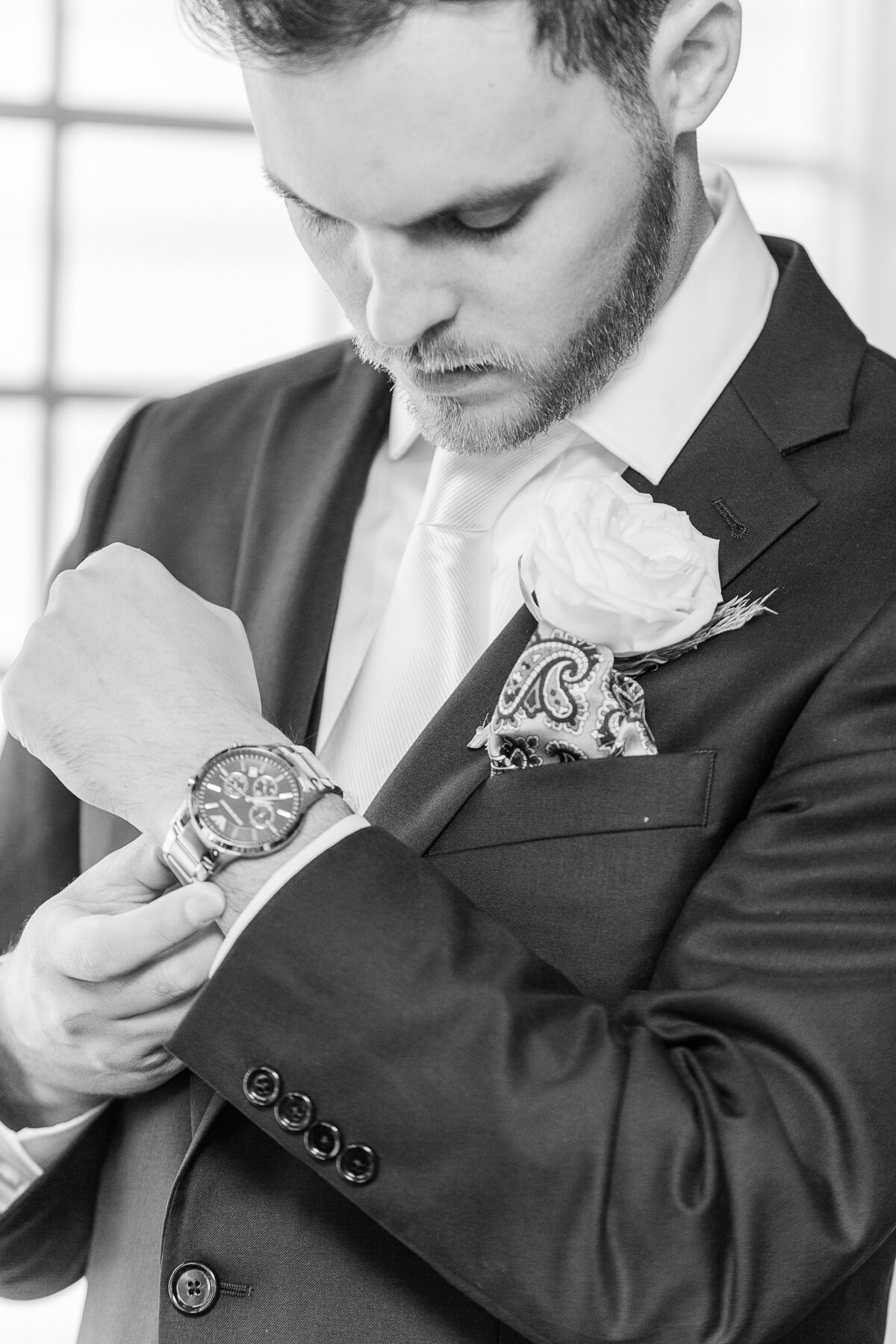 Detail image of groom adjusting his watch before his wedding at the Madison Beach Hotel. Captured by best New England wedding photographer Lia Rose Weddings.