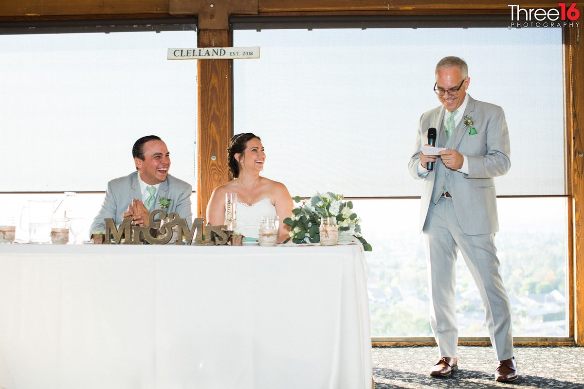 Bride and Groom laugh while listening to the toast