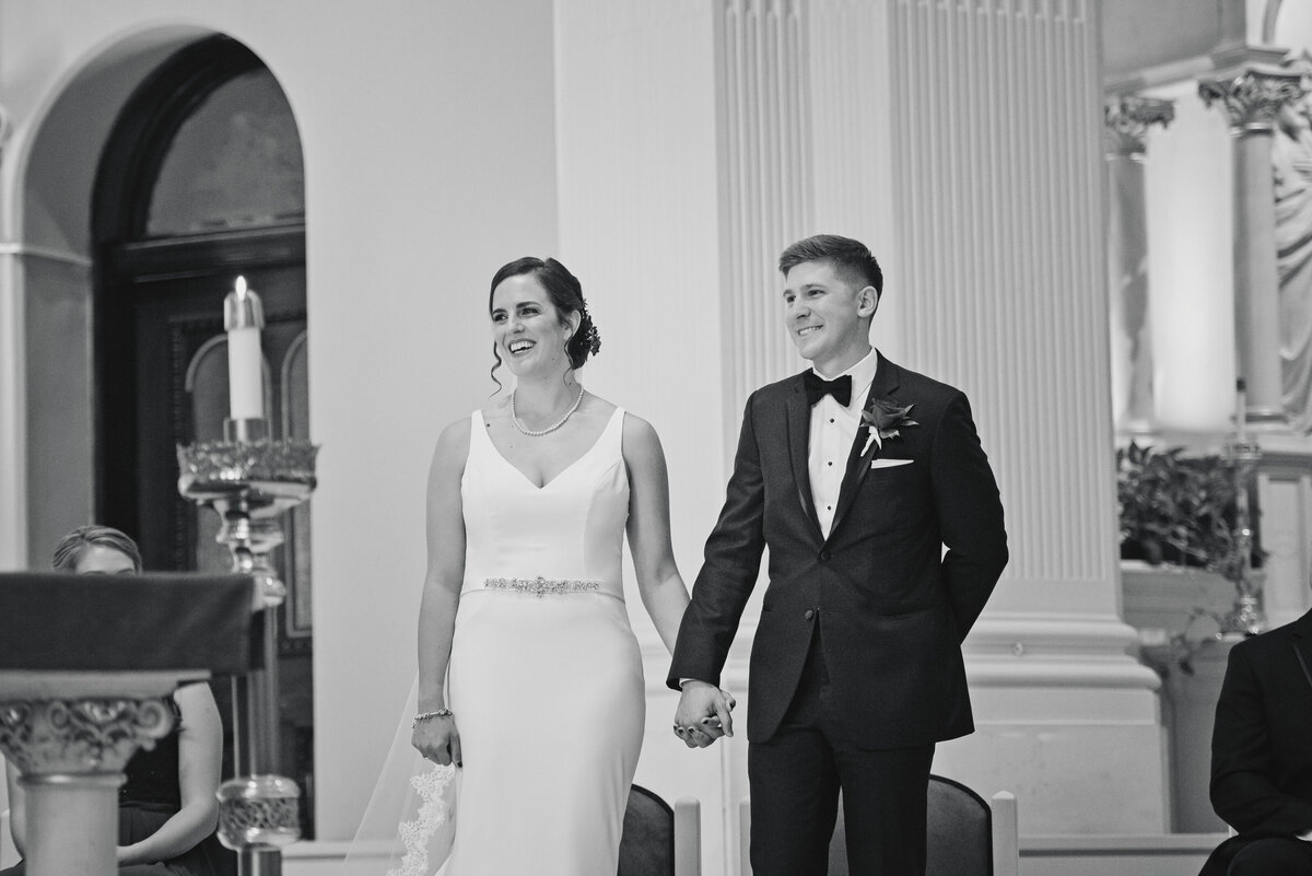 Couple smiling during church wedding ceremony.