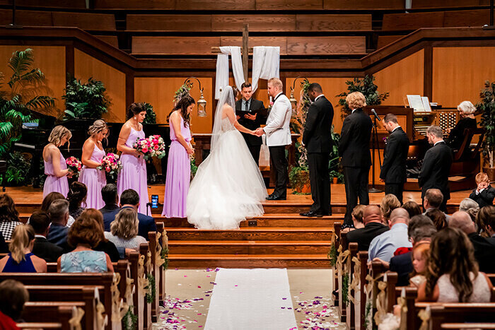 bride-groom-stands-at-altar-flowers