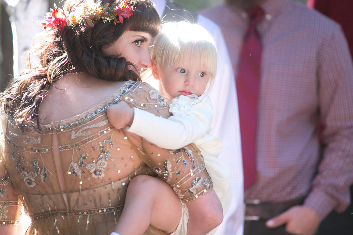 Bride holding daughter during wedding ceremony