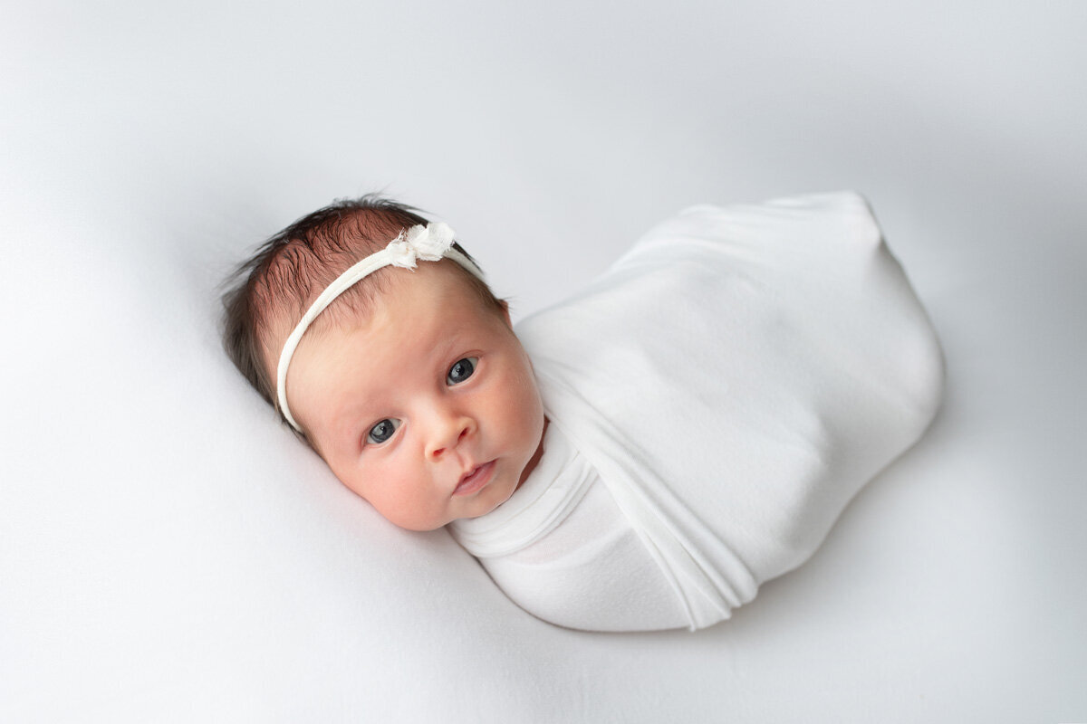 Newborn session of a baby girl wearing a bow