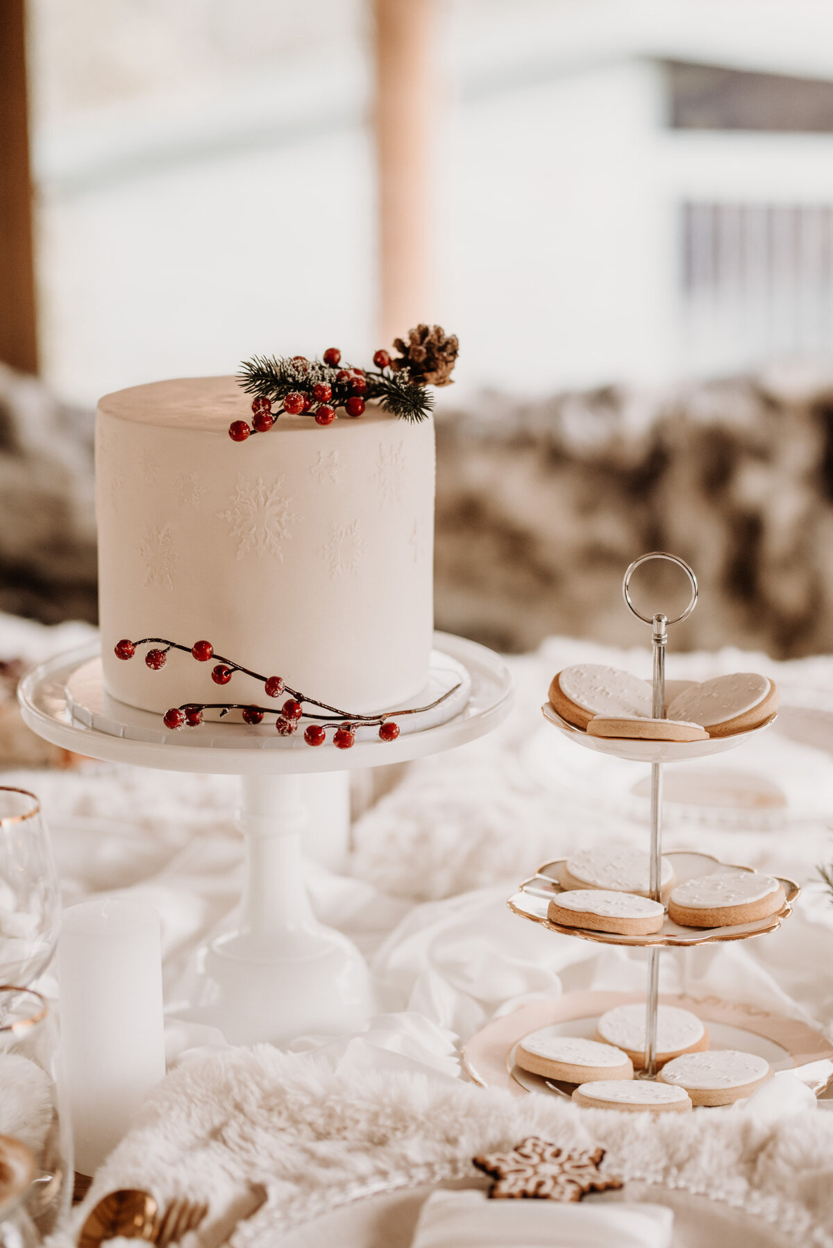 Christmas wedding cake with snowflakes and berries and biscuits for dessert table
