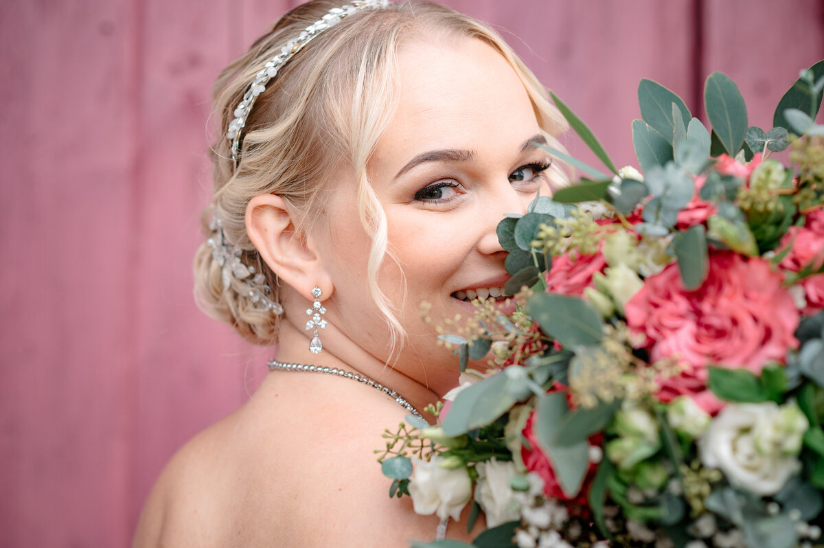 Braut lächelt und hält ihren Brautstrauß hoch Hochzeitsfotograf Murnau