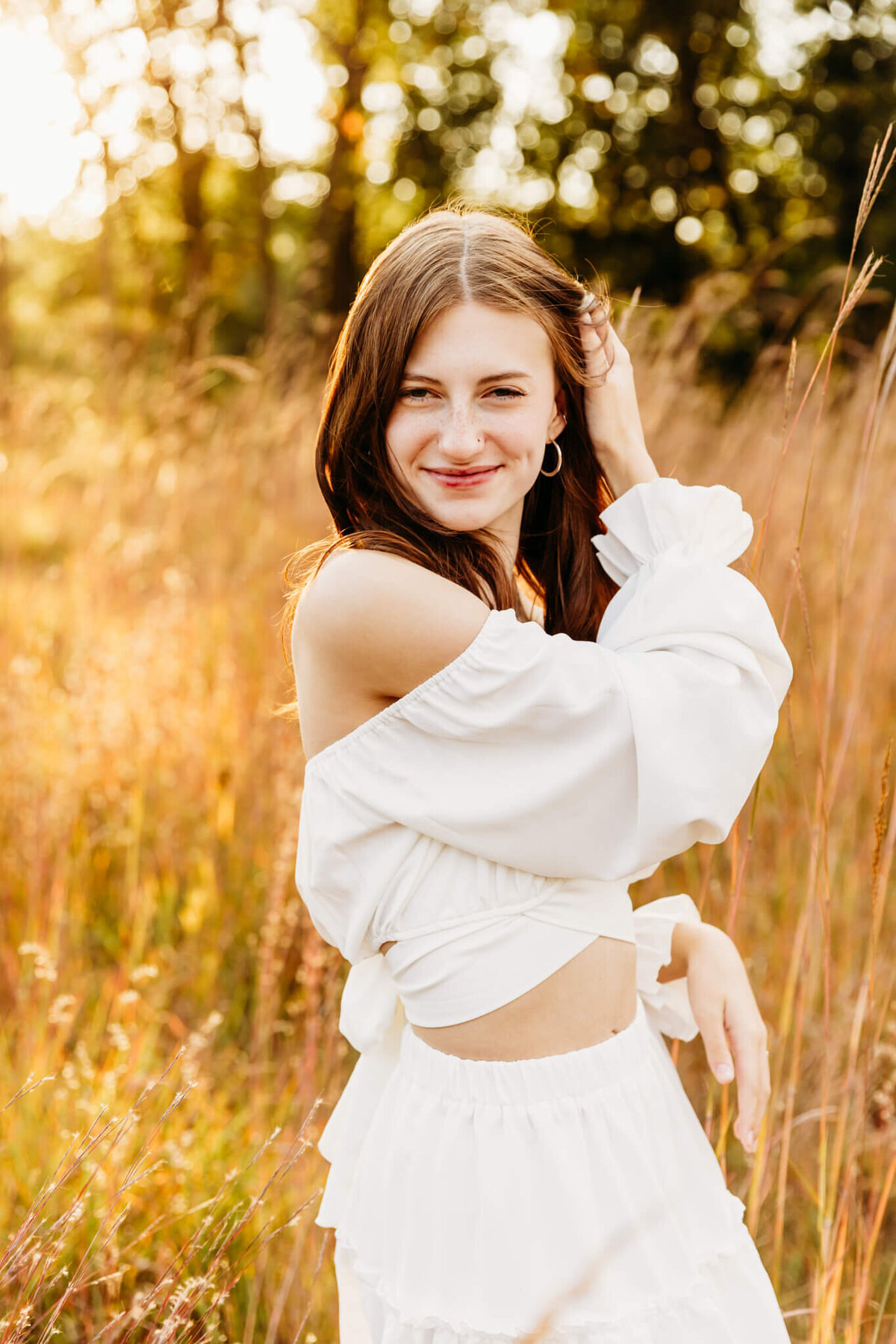 senior girl smiling and playing with her hair by Green Bay Senior Photographer