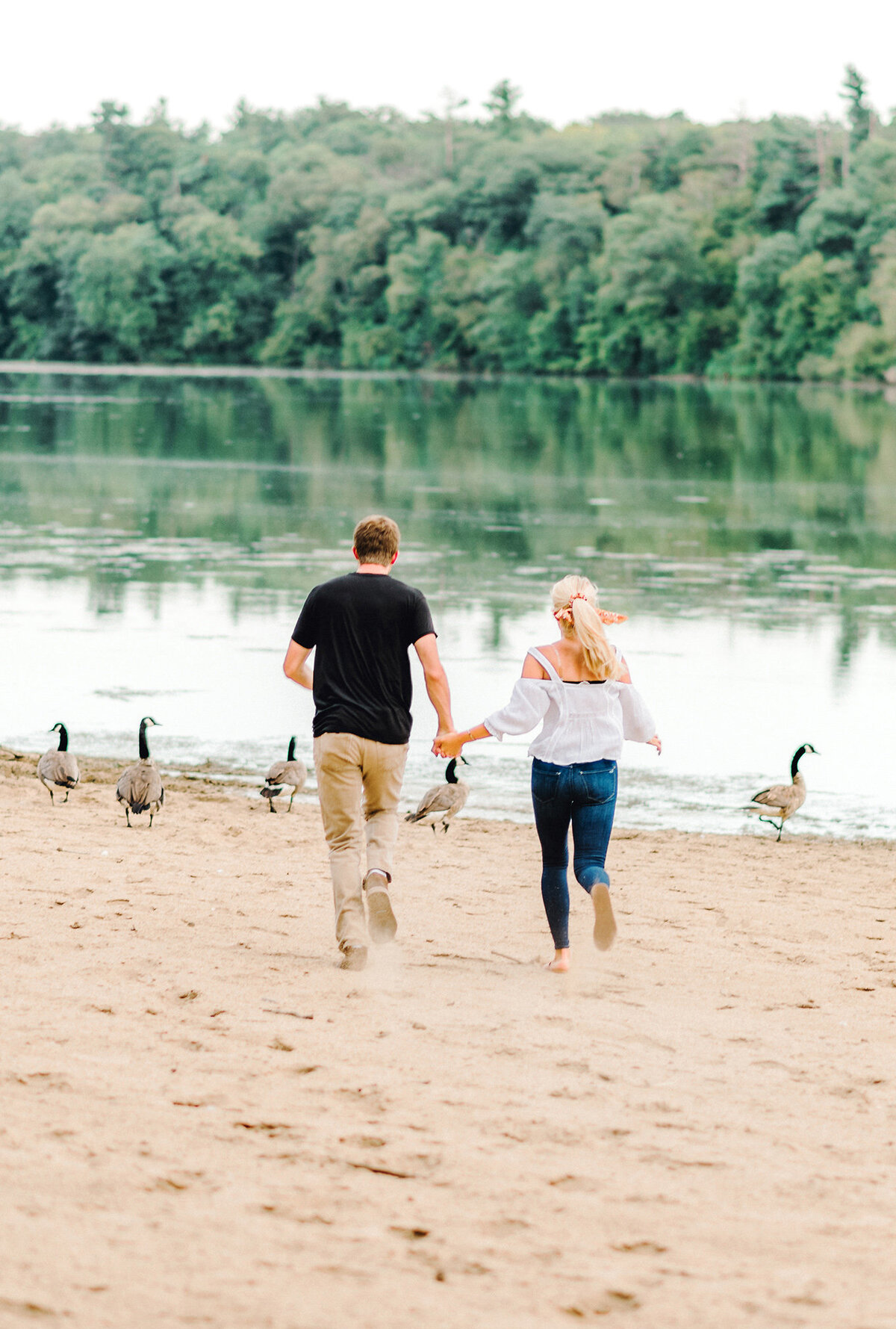 engaged couple runs at pine lake