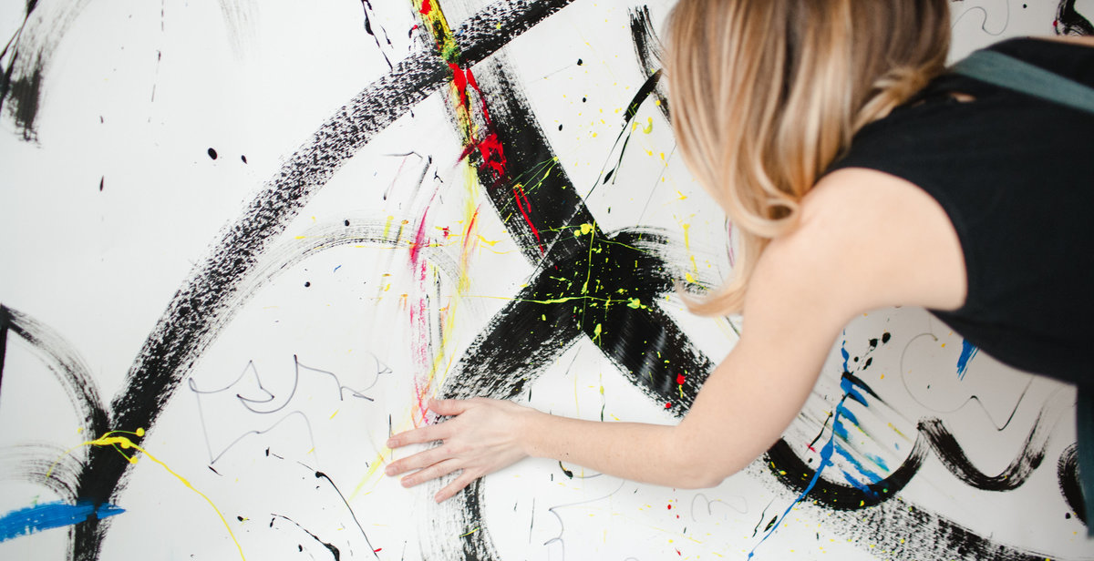 artist painting with her hand on a white background