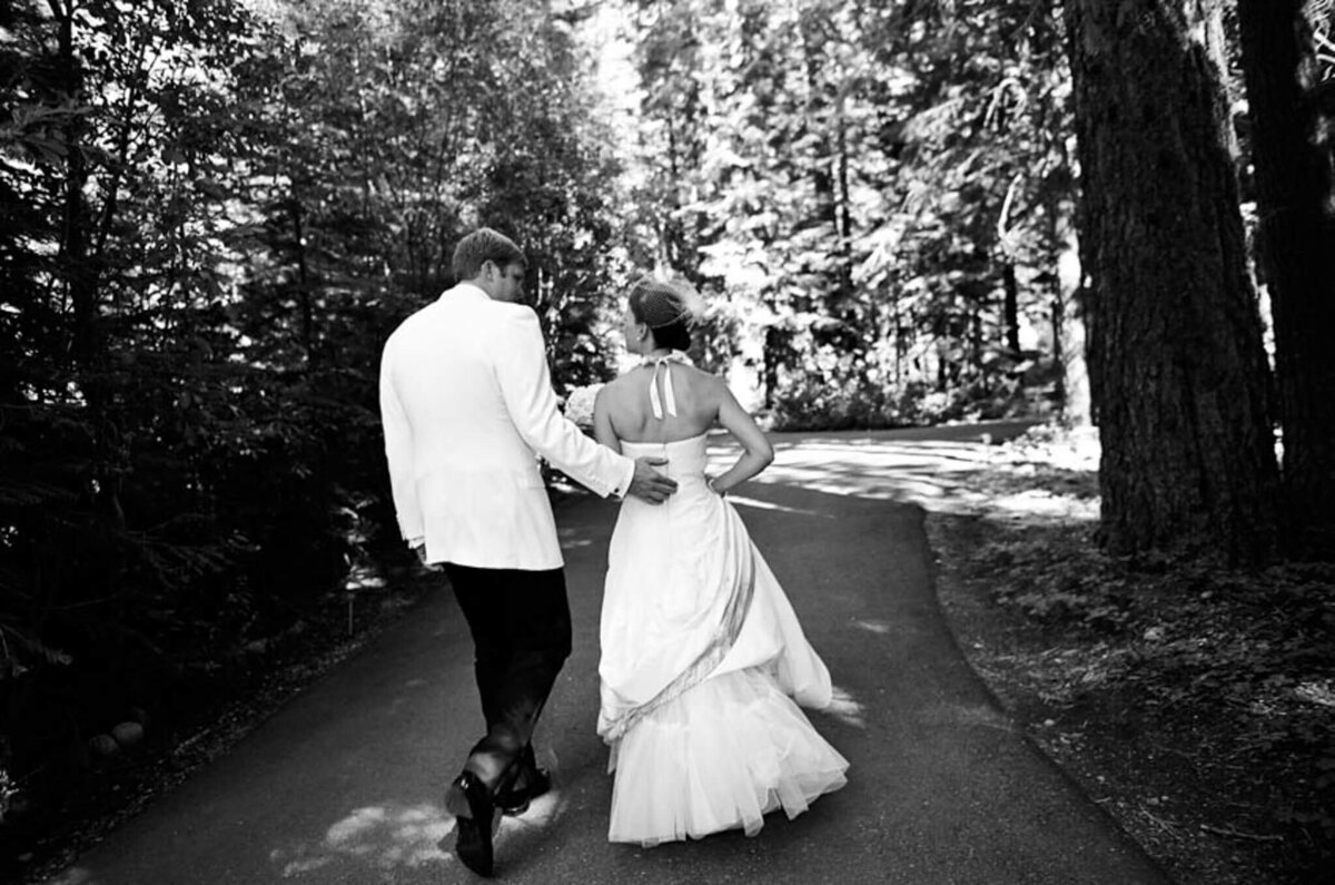 groom in white tux jacket and bride walking on path during Lake Tahoe wedding