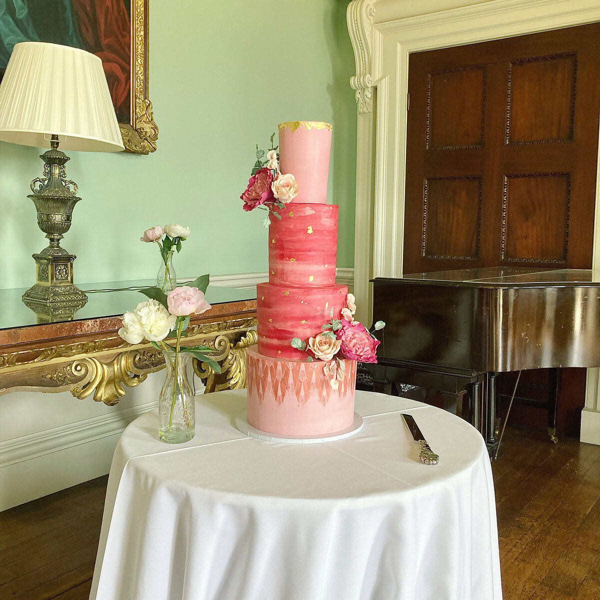 Elegant pink and gold wedding cake with sugar flowers at Kirtlington Park