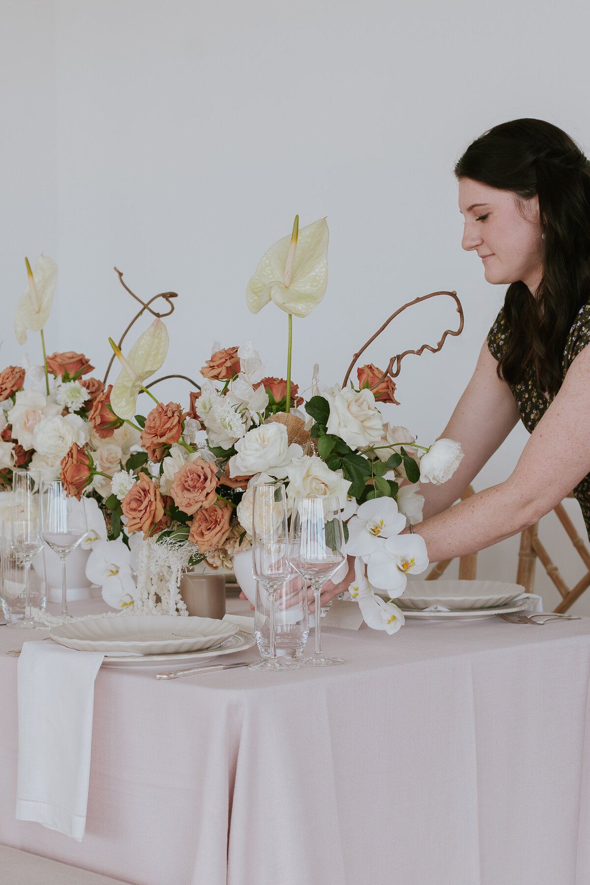 event-planner-placing-floral-arrangement-on-tablescape-for-brand-session-the-frame-charlotte