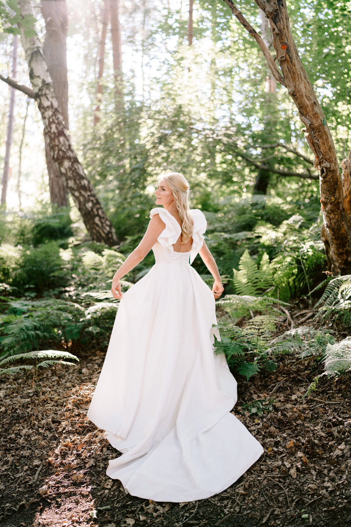 a bride in the woods at peckforton castle on her wedding day