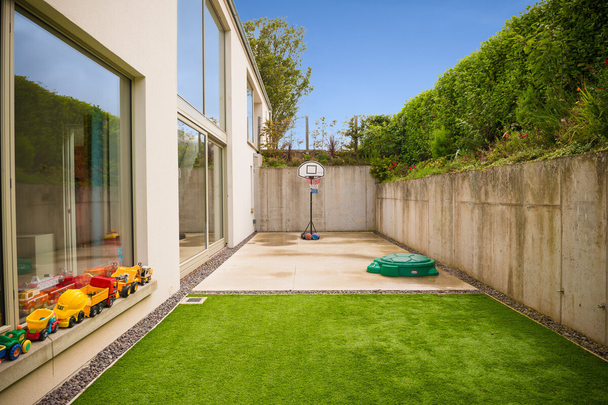 Blow ground level courtyard with faux grass and basketball court
