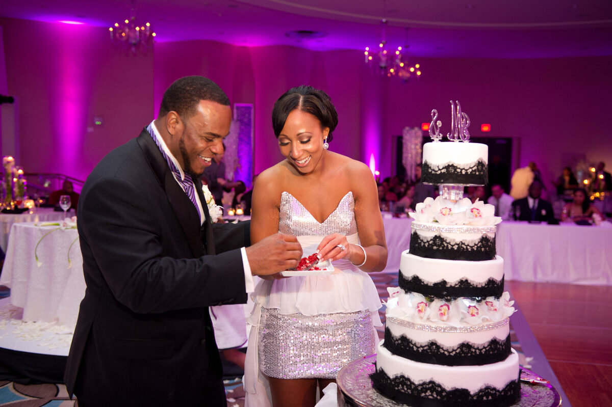 Newly wedded couple cutting their five-tiered black and white cake