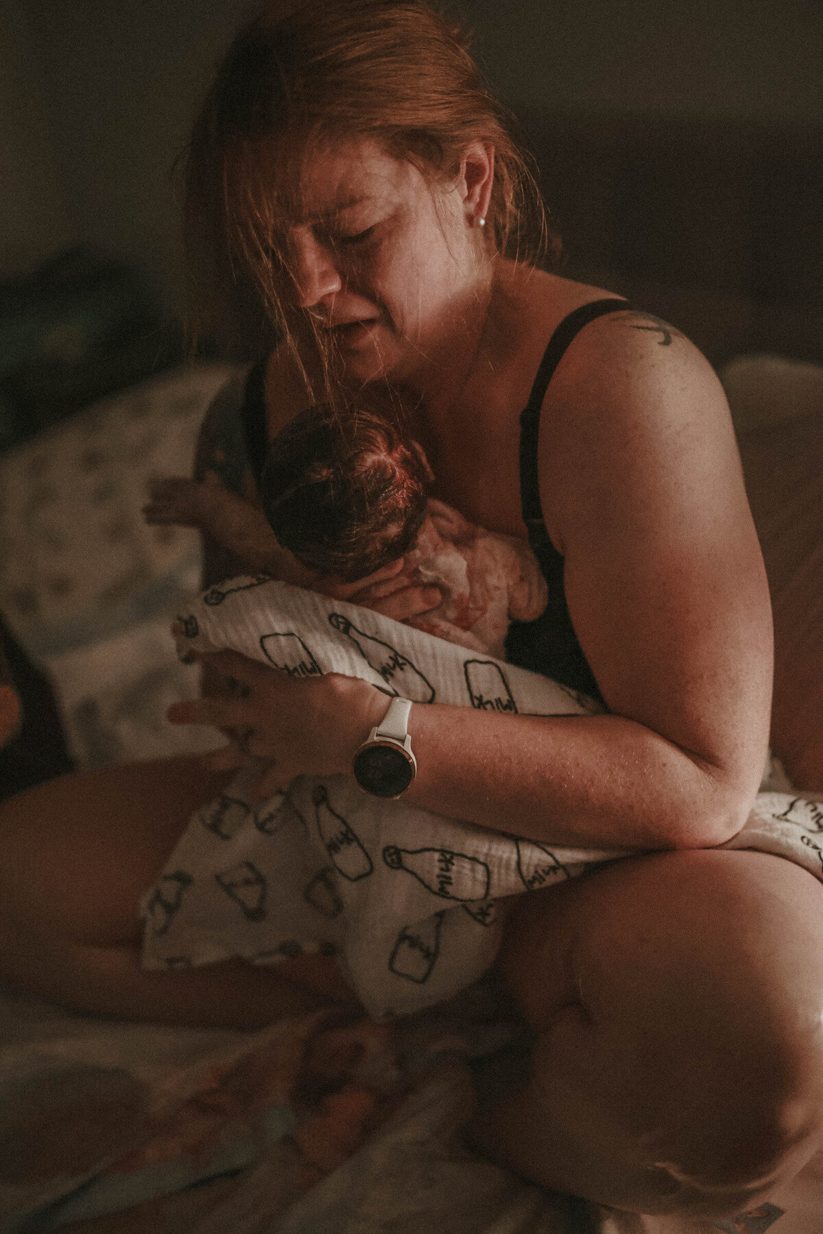 Woman in birthing tub during homebirth, captured in a moment of calm and strength by Savannah, a birth photographer in St. George, Utah.